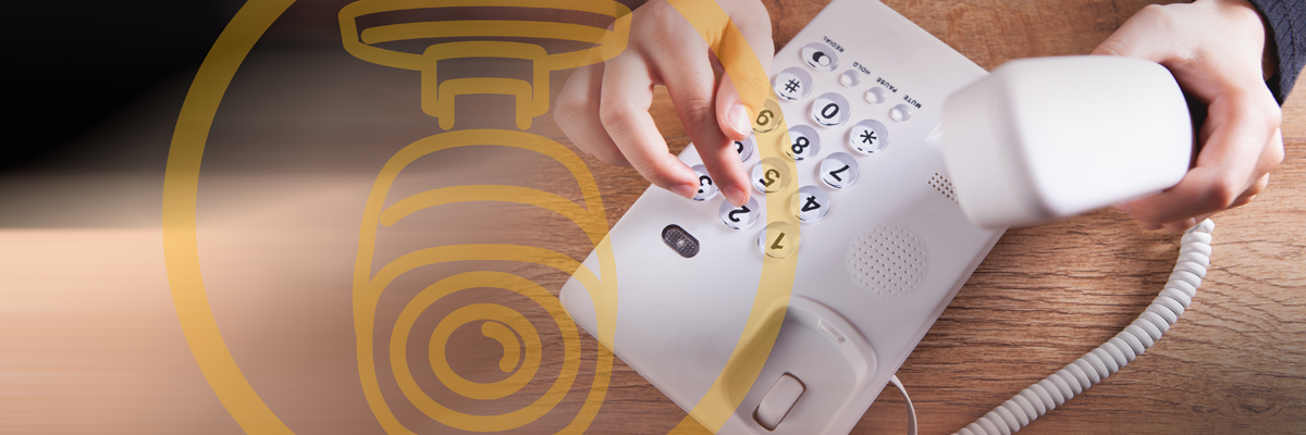 Desktop landline phone being dialed with a camera icon overlay