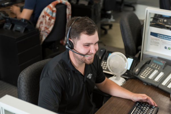 Alarm monitoring specialist on his headset speaking to someone after their alarm sent a signal