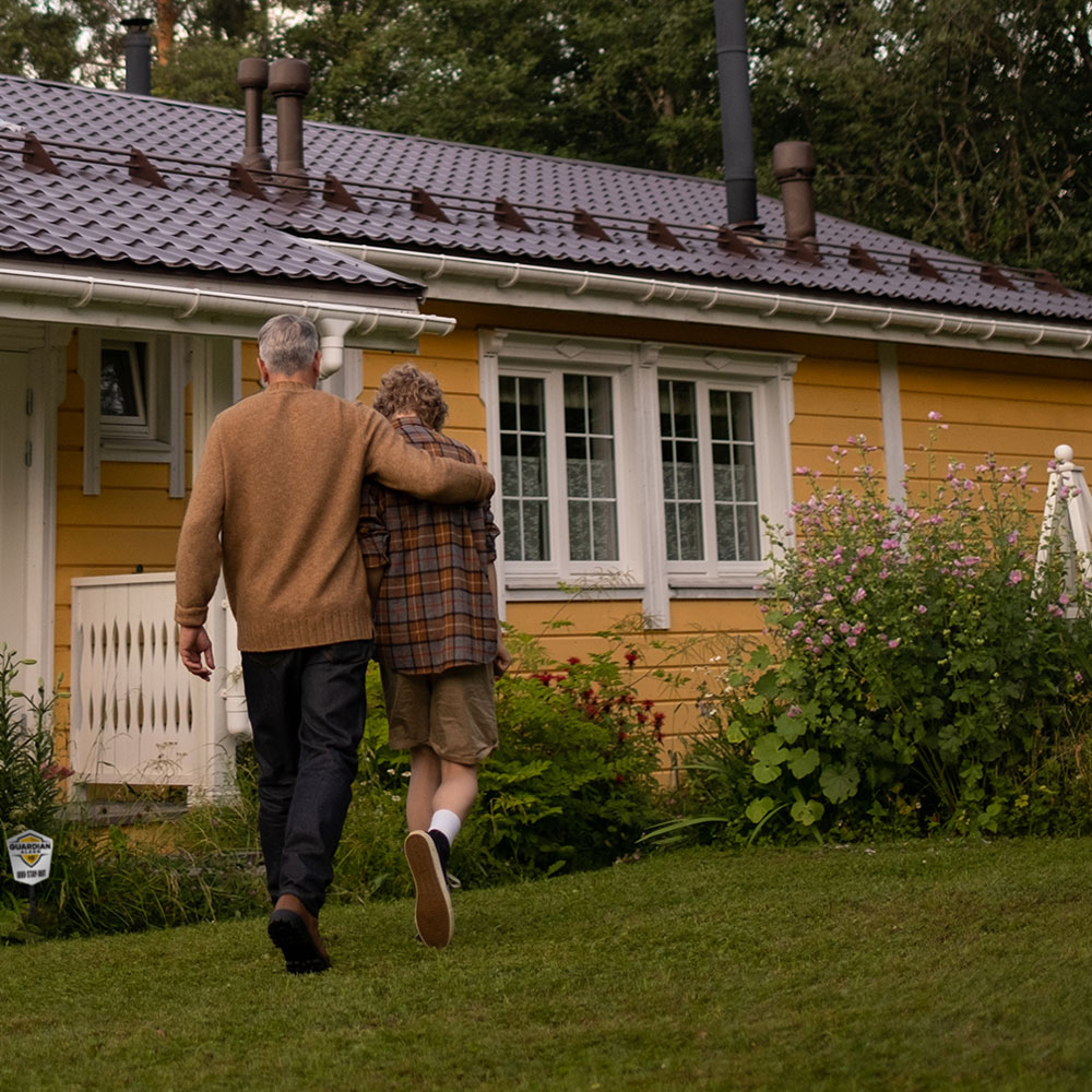 Grandfather with grandson walking into a house protected by Guardian Alarm